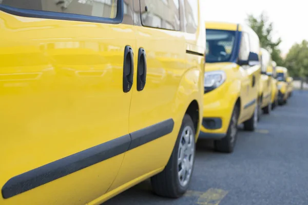 Yellow fleet cars parked in a line. Lined up pick-ups cars.