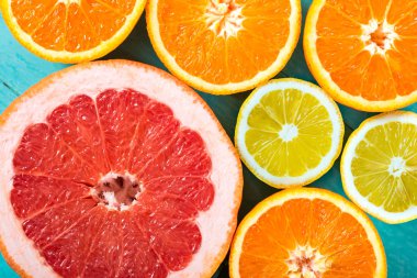 Dilimlenmiş Greyfurt, portakal ve limon. Narenciye meyve toplama mavi ahşap zemin üzerine