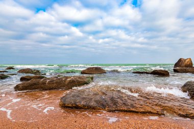 Sahil kayalar ve açık turkuaz su
