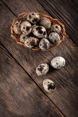 Hasır sepet ahşap arka plan üzerinde bıldırcın yumurtası