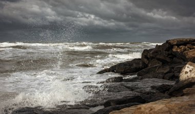 Fırtınalı denizde dalgalar kayaların üzerinde kırmak.