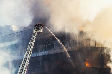 Merdivenlerdeki itfaiyeciler büyük bir yangını söndürdü