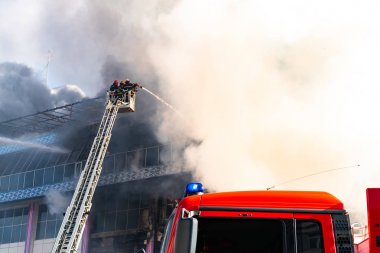 Merdivenlerdeki itfaiyeciler büyük bir yangını söndürdü