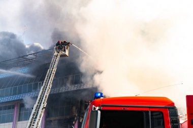 Merdivenlerdeki itfaiyeciler büyük bir yangını söndürdü