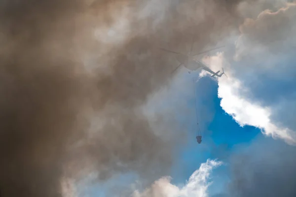 Спасательный вертолет сбрасывает воду тушит огонь — стоковое фото