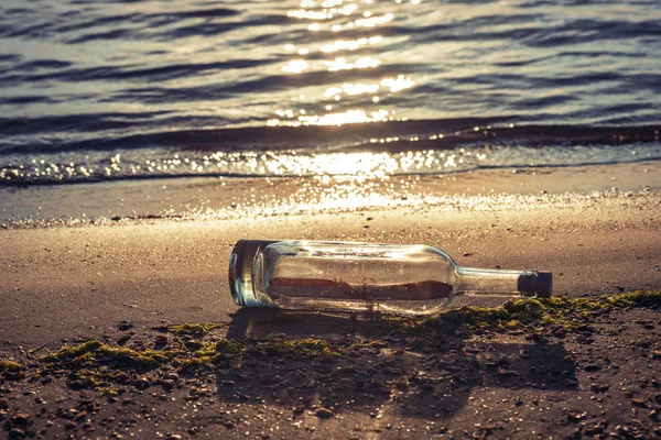 Message in a corked bottle on the shore, hope of salvation Stock Photo