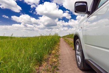 Tarım alanları arasında kırsal toprak yolda araba