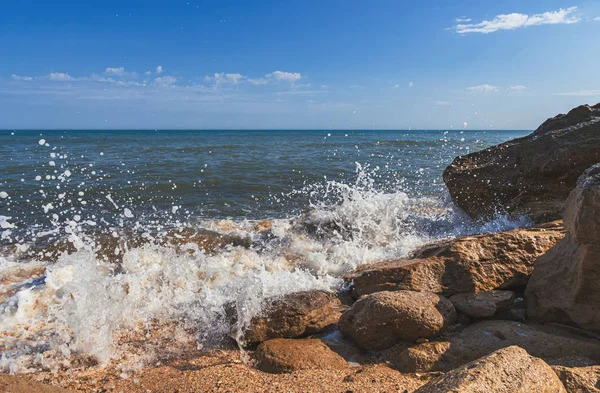 Summer beach with rocks and splashing waves — Stock Photo, Image