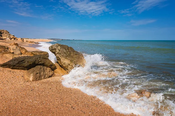 Summer beach with rocks and splashing waves — Stock Photo, Image