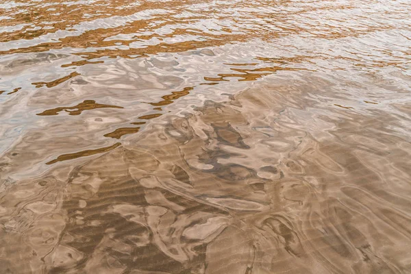 Surface d'eau lisse avec fond de sable — Photo