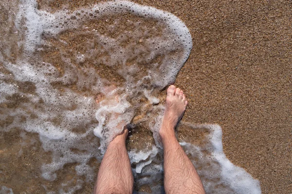 Bare feet on the ocean shore