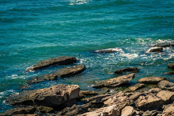 Морское побережье с каменистым берегом и мелкими волнами — стоковое фото