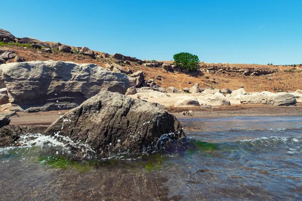 Berrak su ve dalgalar ile kayalık sahil — Stok fotoğraf