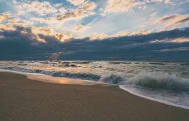 Renkli gün batımında dalgalar ile Plaj