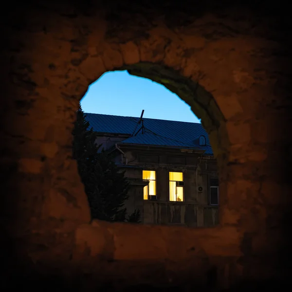 Illuminated night window of old house