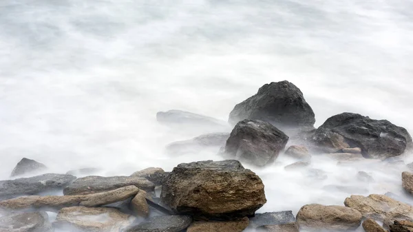 Storm in de zee, grote schuimige golven crash op rotsen — Stockfoto