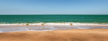 Turkuaz deniz ve sarı kumlu sahil, tatil köyü.