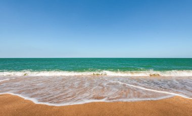 Turkuaz deniz ve sarı kumlu sahil, tatil köyü.