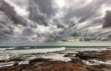 Bulutlu havada kayalık sahil kenarı