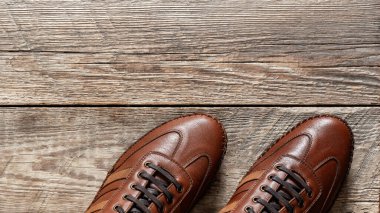 Ahşap arka planda izole edilmiş deri spor ayakkabılar.