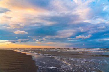 Gün batımında kumsalda Güzel bulutlar ve hafif fırtınalı denizler