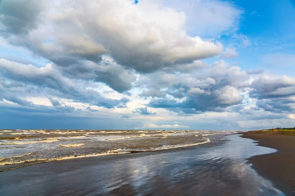 Gün batımından sonra siyah volkanik kumu olan boş bir sahil.