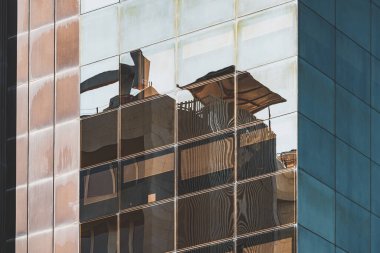 Reflections on the corner of the glass facade of an office building clipart