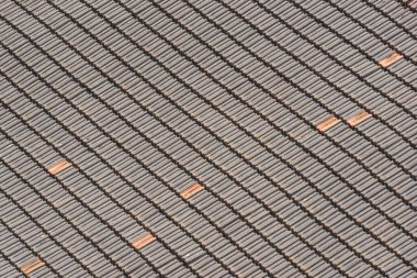 Eski bir çatının geleneksel terasotta fayanslarının arka planı köşegen desen oluşturuyor