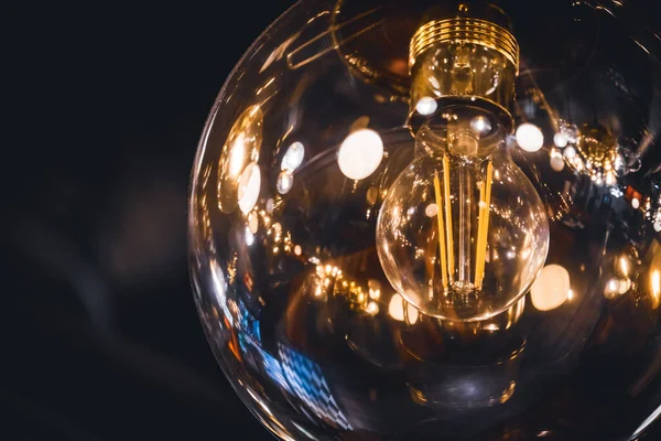 Giant vintage style light bulb lit with its retro filaments visible inside