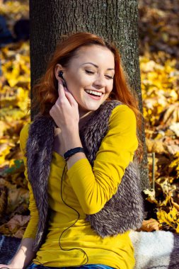 Sonbaharda parkta müzik dinleyen genç güzel kadın