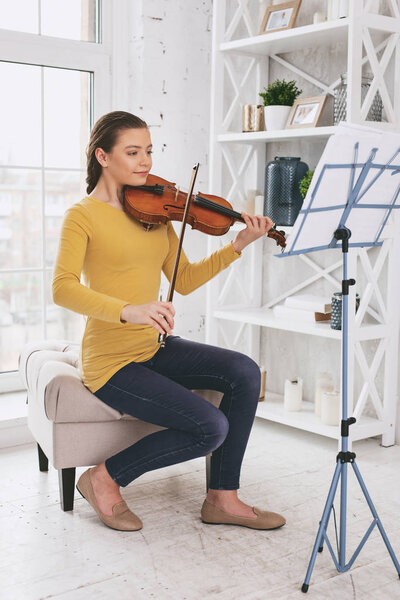 Serious student sitting in front of reading-stand