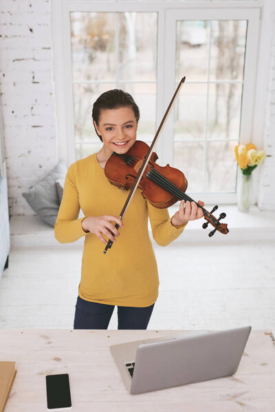 Joyful schoolgirl learning classical melody
