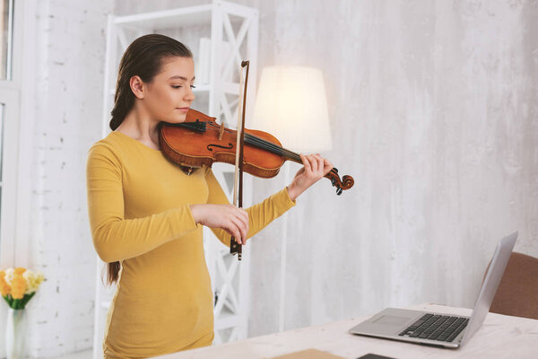 Conscious teenager playing the violin