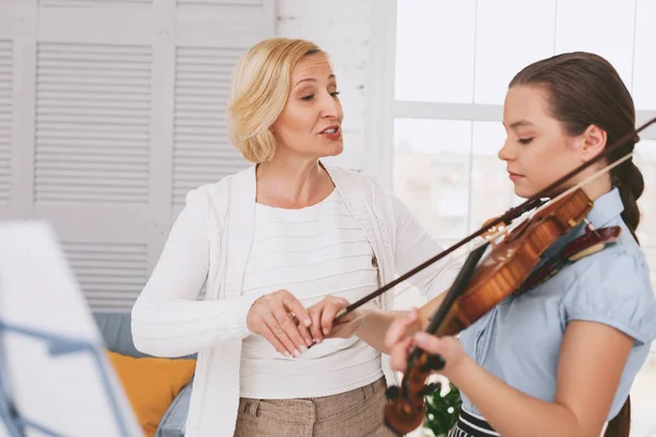 Chica concentrada tratando de tocar el violín — Foto de Stock