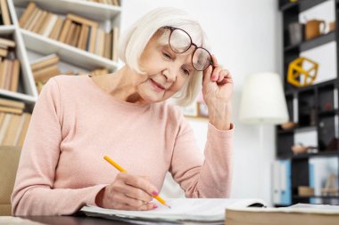 Pleasant senior woman inserting answers clipart