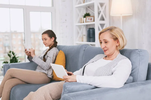 Uppmärksamma pensionär tittar på hennes gadget — Stockfoto