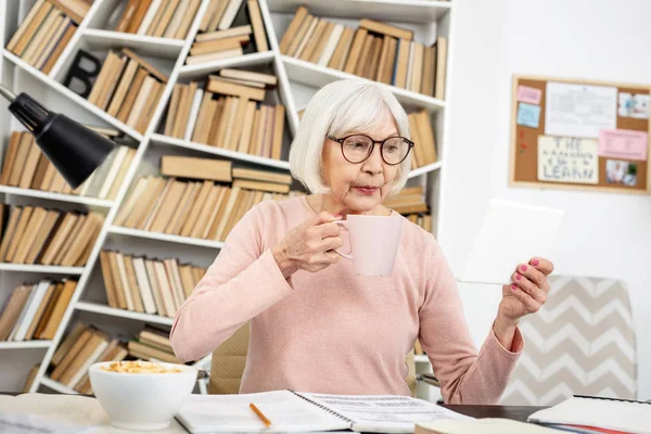 Serious senior woman reviewing lecture — Stock Photo, Image