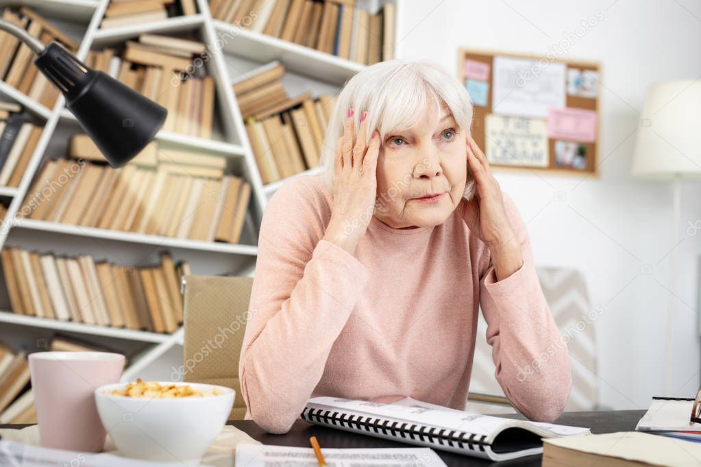 Sad mature woman exhausting from learning
