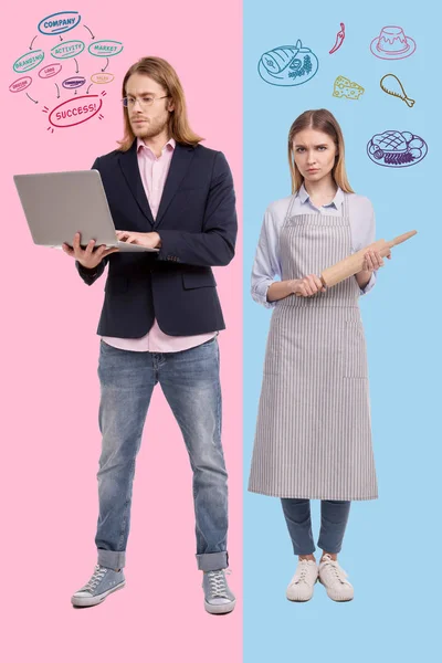 Tråkiga fru står med en brödkavel när maken upptagen håller en laptop — Stockfoto