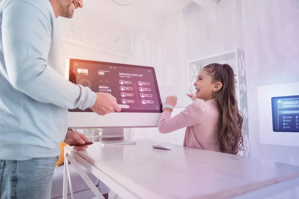 Chica positiva riendo mientras sostiene una tableta moderna —  Fotos de Stock