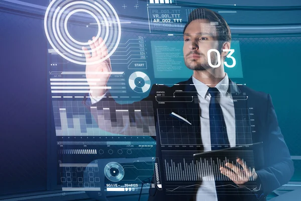 Hombre guapo en un traje tocando la pantalla transparente y buscando calma —  Fotos de Stock