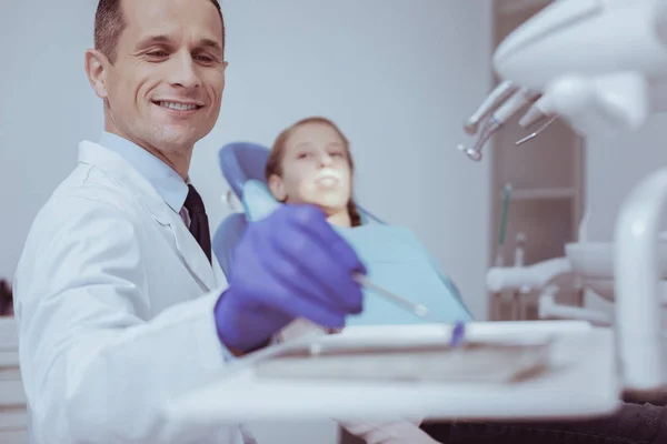 Dentista masculino feliz escolhendo espelho de boca — Fotografia de Stock