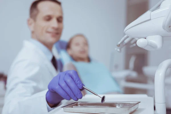 Αρσενικό οδοντίατρος λαμβάνοντας στοματικός καθρέφτης — Φωτογραφία Αρχείου
