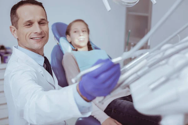 Médico dentista experiente alongamento para ferramenta dentária — Fotografia de Stock