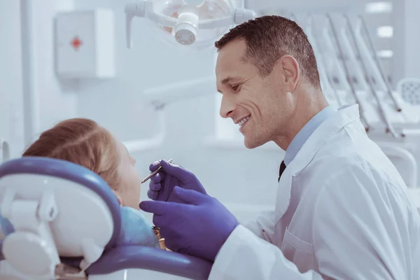Dentista masculino alegre verificando dentes — Fotografia de Stock