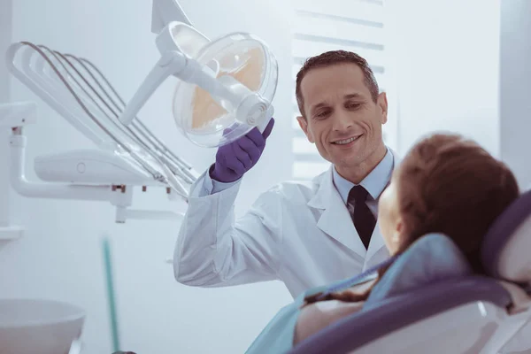 Freudiger männlicher Zahnarzt überprüft Mundreinigung — Stockfoto