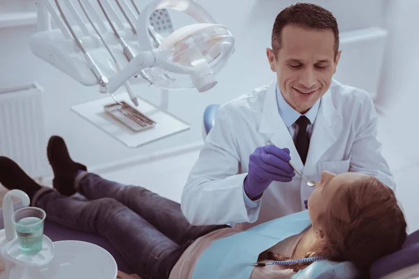 Optimistic male dentist observing oral cavity — Stock Photo, Image