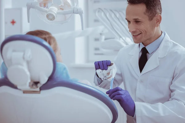 Dentista masculino seguro haciendo modelo de prótesis dentales — Foto de Stock