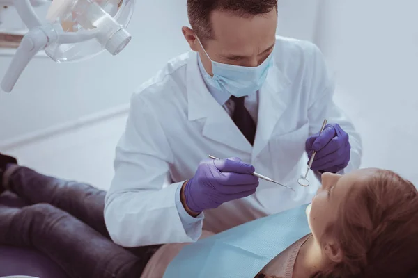 Dentista varón confiado realizando chequeo —  Fotos de Stock