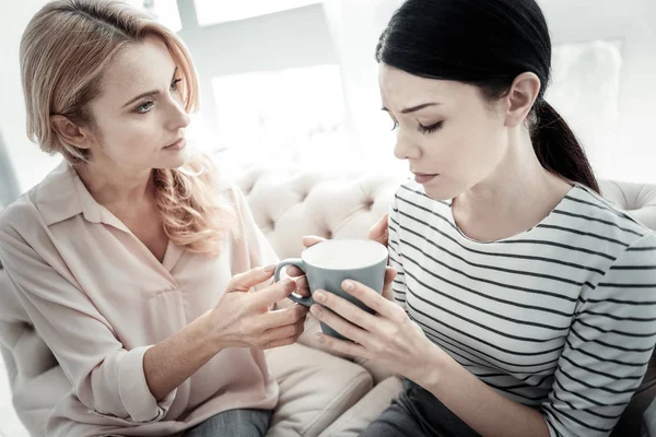 Försiktig söt kvinna sitter och lugnande hennes vän. — Stockfoto